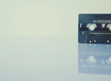 A cassette tape on a white background and reflective white floor
